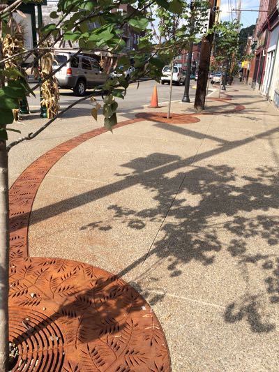 A view of city sidewalks with combination drain-and-infiltration openings, decoratively installed.